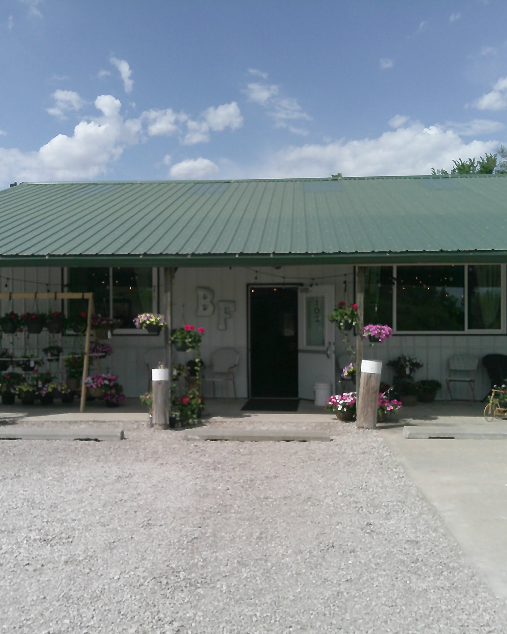 The Bennington Farms storefront with a green metal roof and hanging flower baskets
